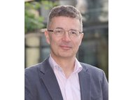 Man in a formal suit standing outdoors.