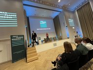 Bühne bei Max Planck Schools Day 2024 mit Präsentation und Publikum im Konferenzsaal.