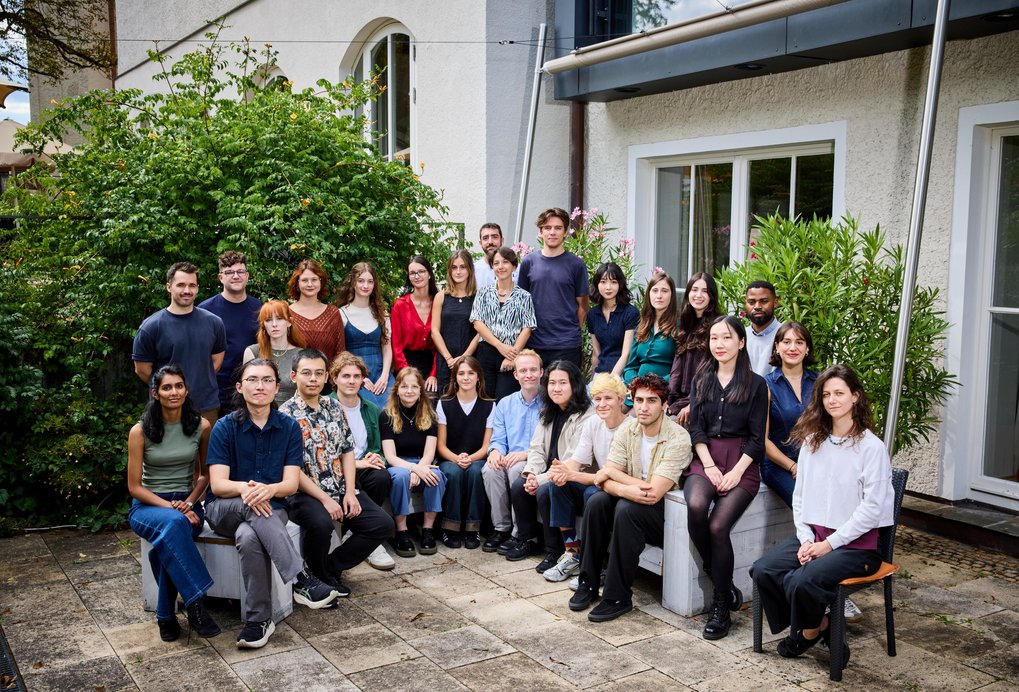A large group of people pose for a photo in a half circle.