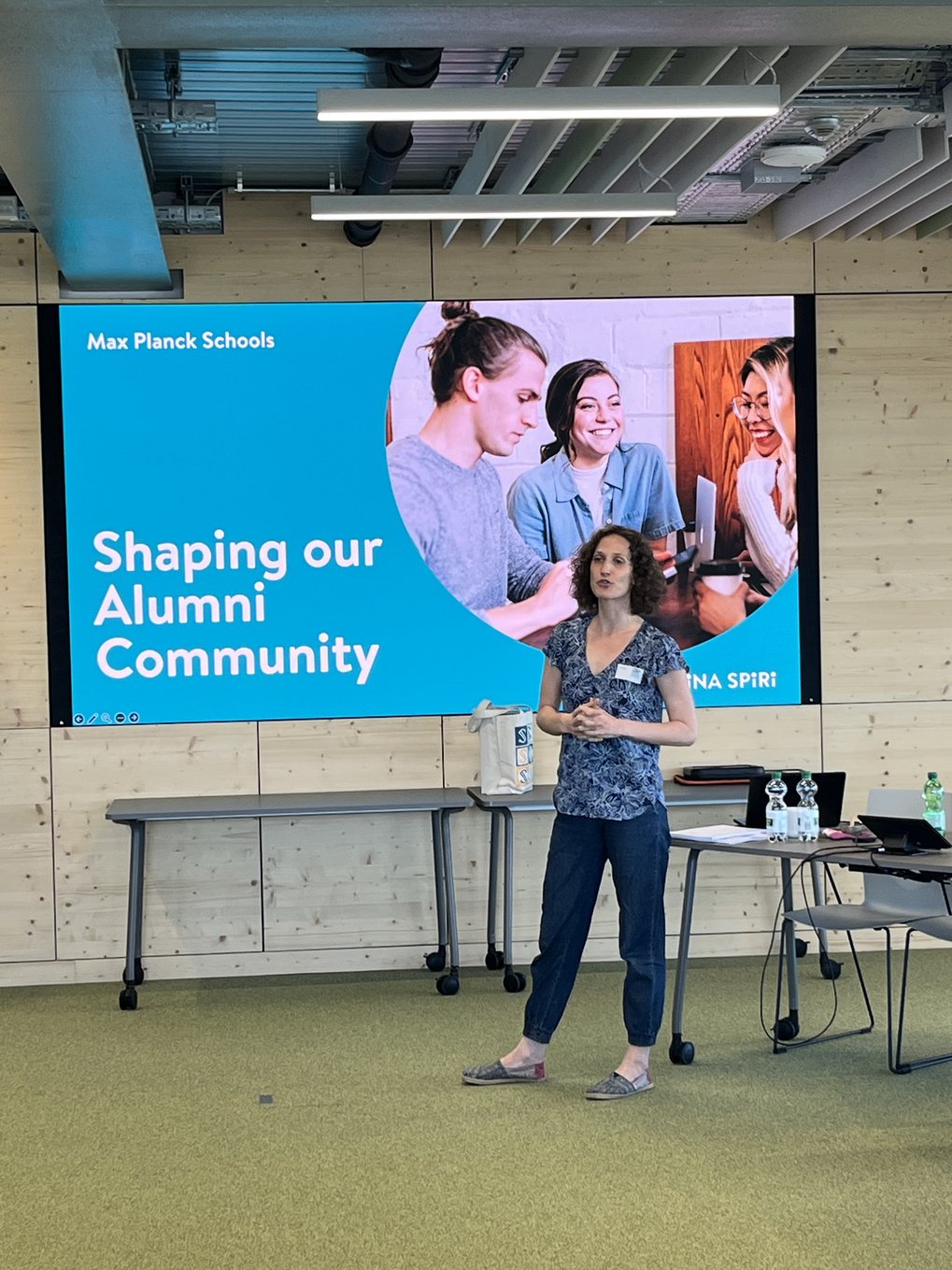 A coach is speaking in front of a Presentation on Alumni Networking.