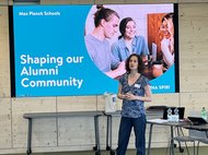 A coach is speaking in front of a Presentation on Alumni Networking.