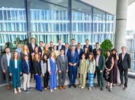 Viele Personen in festlicher Kleidung stehen als Gruppe zusammen.