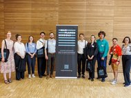 Absolventen stehen vor einem Poster der Max Planck Schools