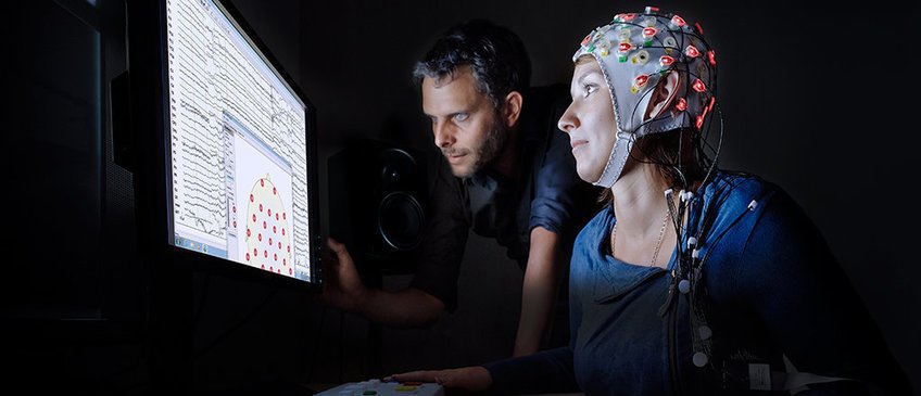 News Two people observe a monitor with MRI data.